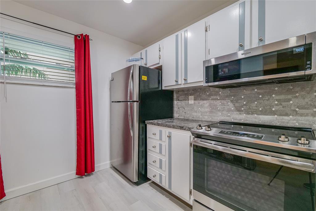 3930 Inverrary Boulevard, Unit 407D Lauderhill, FL 33319 - Photo 10 of 60 a kitchen with stainless steel appliances a stove a microwave and a refrigerator
