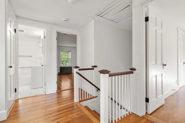 a view of a hallway with wooden floor and staircase