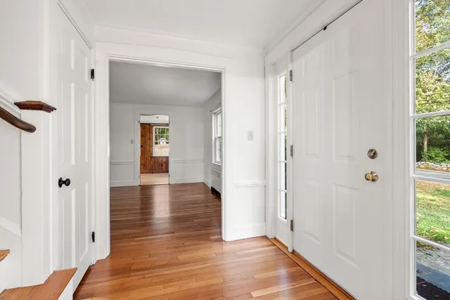 a view of a hallway with wooden floor and closet area