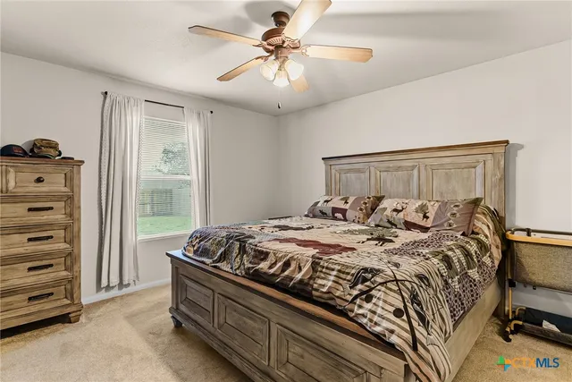 a bed sitting in a bedroom next to a window