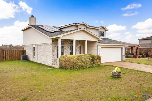 a view of a house with backyard and a tree