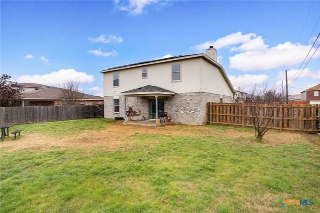 a view of a house with backyard and sitting area