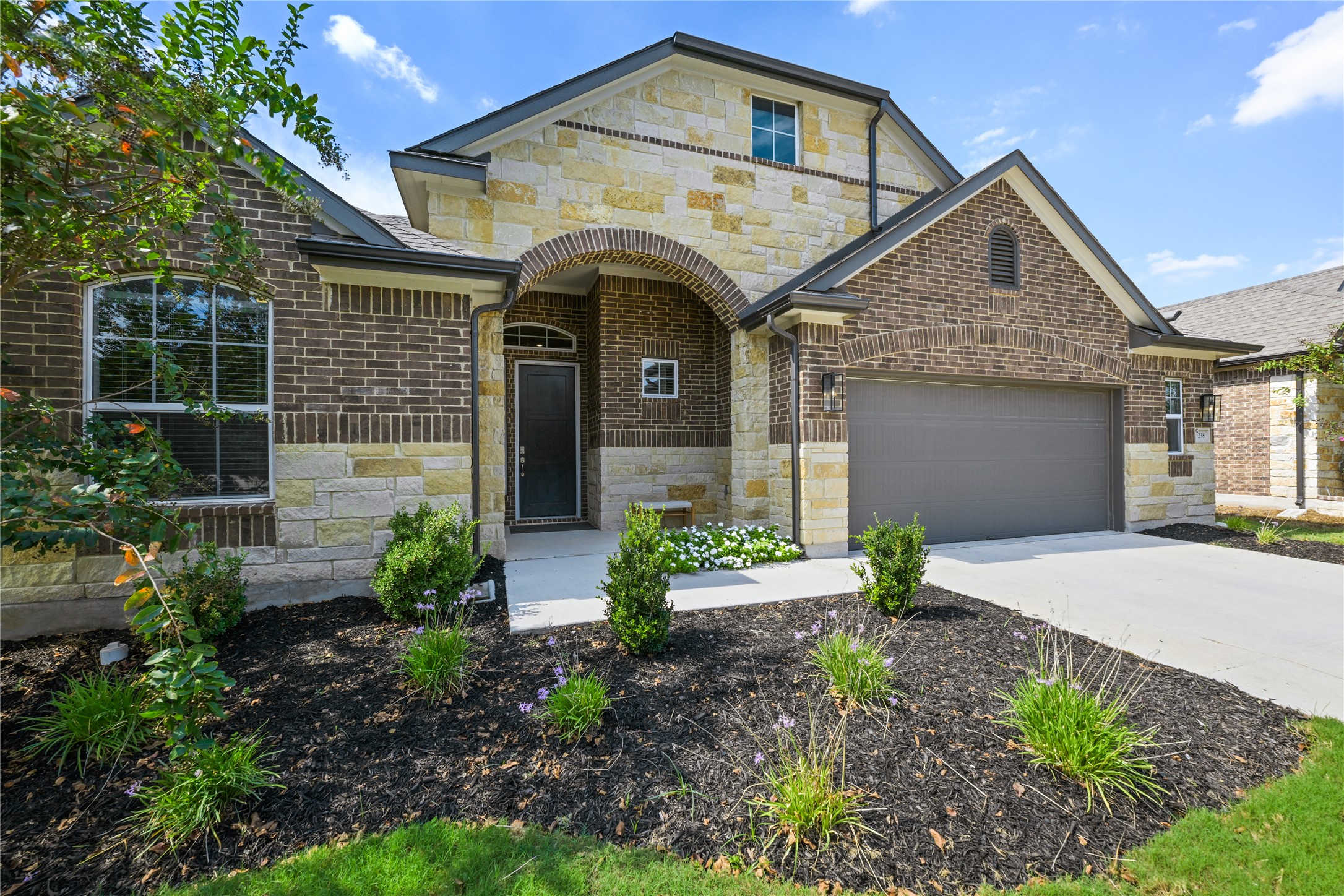 238 Wild Pecan Loop Buda, TX 78610 - Photo 2 of 31 Exquisite brick and stone masonry defines the facade of this two-story traditional home.