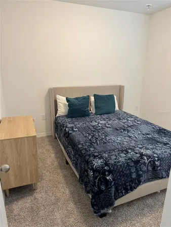 a large bed sitting in a bedroom next to a lamp