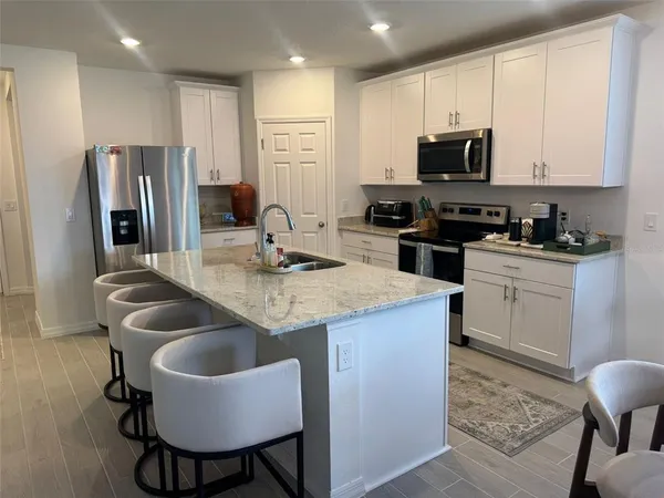 a kitchen that has a sink cabinets and stainless steel appliances
