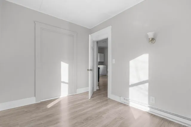 an empty room with wooden floor and a window