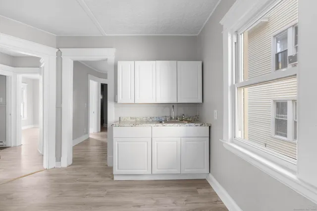 a kitchen with a refrigerator and white cabinets