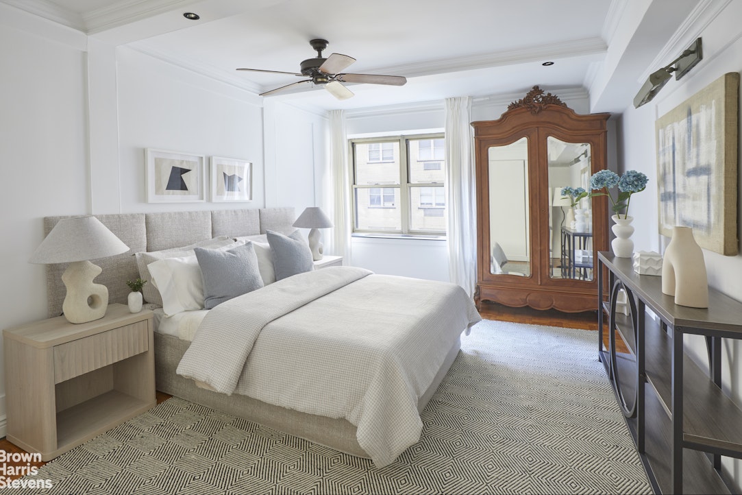 415 East 52nd Street, Unit 6GC Manhattan, NY 10022 - Photo 10 of 15 a spacious bedroom with a bed a couch and a chandelier