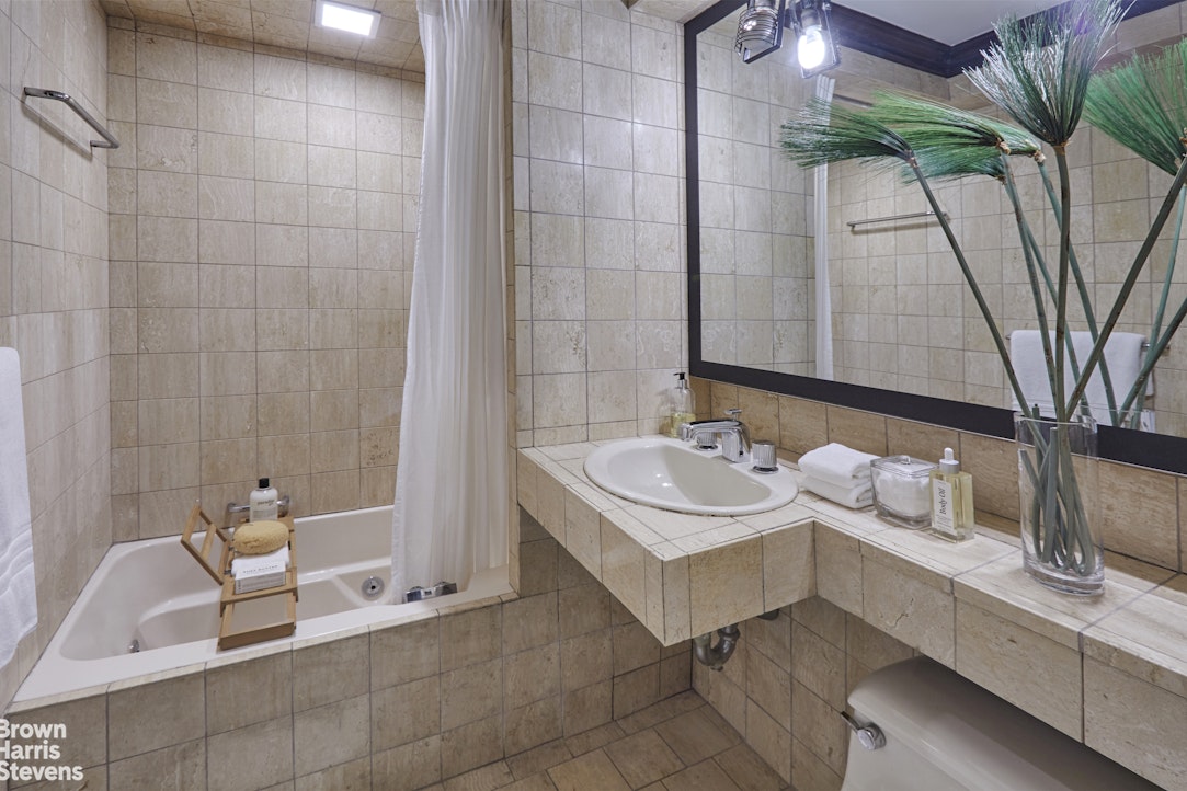 415 East 52nd Street, Unit 6GC Manhattan, NY 10022 - Photo 11 of 15 a bathroom with a sink and a mirror