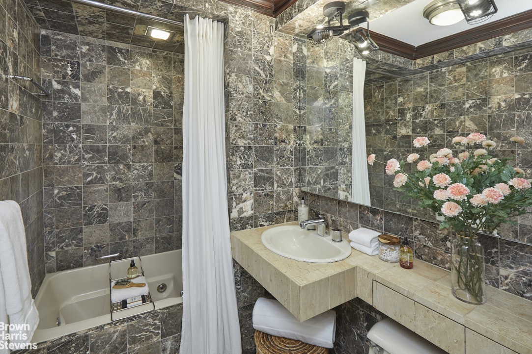 415 East 52nd Street, Unit 6GC Manhattan, NY 10022 - Photo 13 of 15 a bathroom with a sink and mirror with bathtub