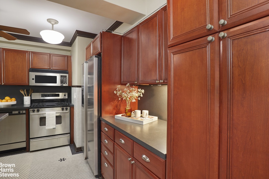 415 East 52nd Street, Unit 6GC Manhattan, NY 10022 - Photo 8 of 15 a kitchen with stainless steel appliances a refrigerator and cabinets