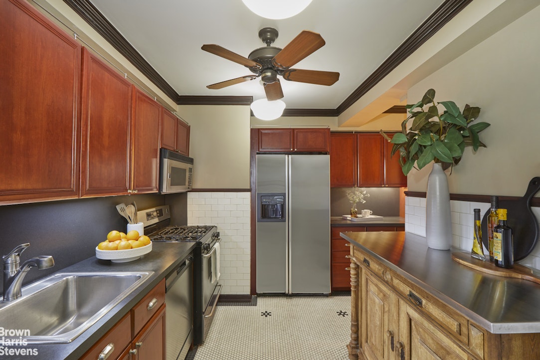 415 East 52nd Street, Unit 6GC Manhattan, NY 10022 - Photo 9 of 15 a kitchen with stainless steel appliances a sink a refrigerator a counter space and a sink