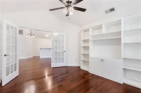 a view of an empty room with a window and wooden floor