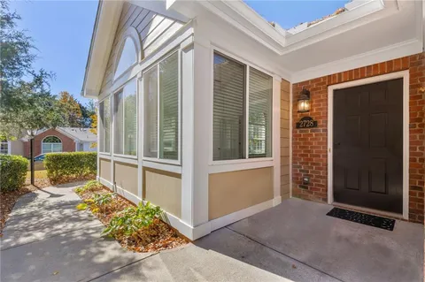 a view of backyard with large windows and a large tree