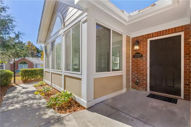 a view of backyard with large windows and a large tree