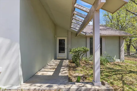 an empty room with chandelier fan and windows