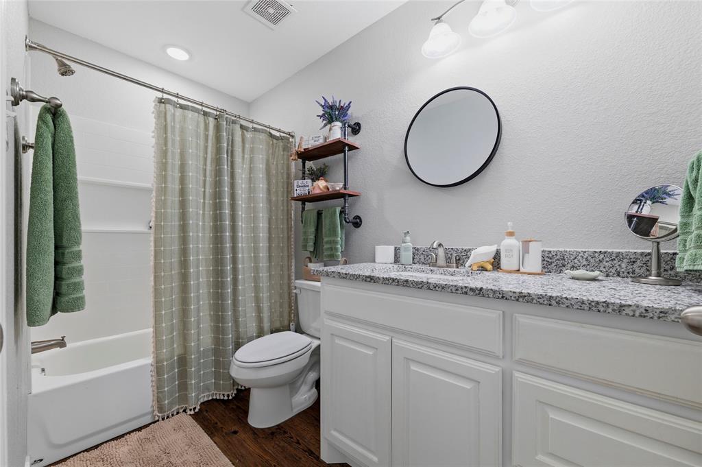 300 West Main Street Itasca, TX 76055 - Photo 12 of 31 a bathroom with a granite countertop toilet sink and a mirror