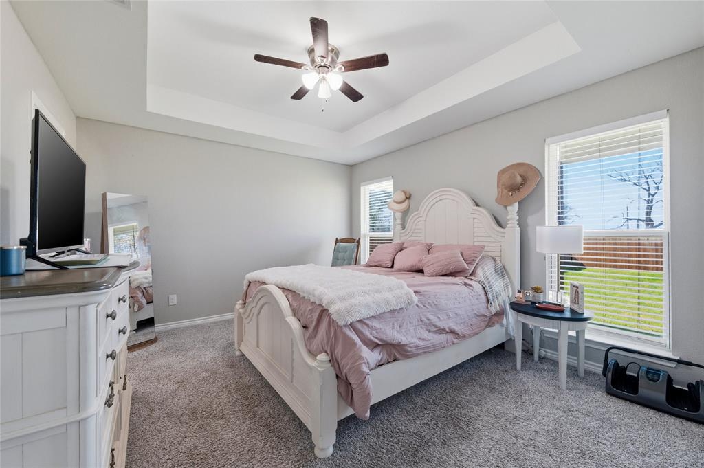 300 West Main Street Itasca, TX 76055 - Photo 10 of 31 a bedroom with a bed a chandelier and a flat tv screen