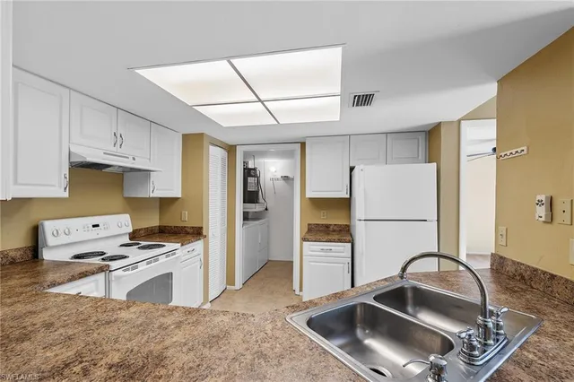 a kitchen with granite countertop a sink stove and refrigerator