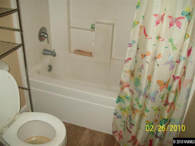 9815 Meadowstar Drive Reno, NV 89506 - Photo 6 of 9 a bathroom with a toilet and a shower curtain