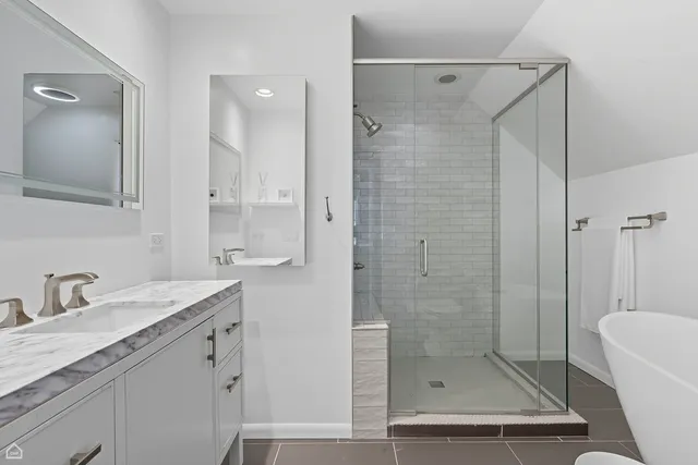 a bathroom with a shower sink vanity and mirror