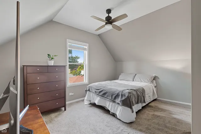 a spacious bedroom with a bed and a dresser