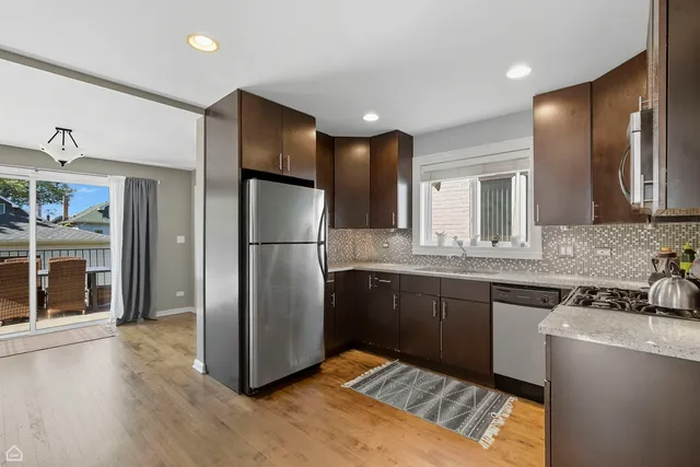a kitchen with stainless steel appliances granite countertop a refrigerator and a sink