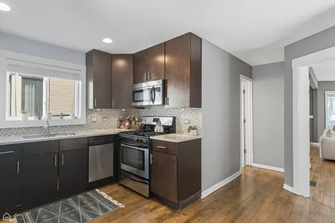 a kitchen with stainless steel appliances granite countertop a sink stove and refrigerator