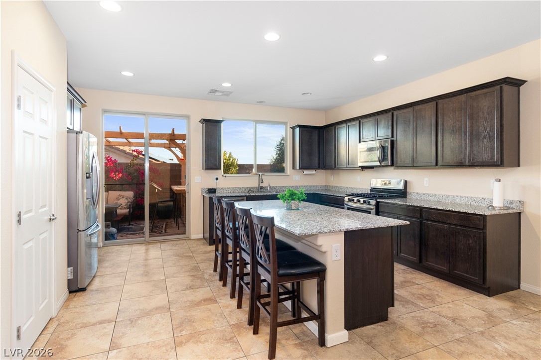 2079 Port Royal Drive Laughlin, NV 89029 - Photo 12 of 86 Kitchen featuring light stone countertops, a breakfast bar area, a center island, appliances with stainless steel finishes, and recessed lighting