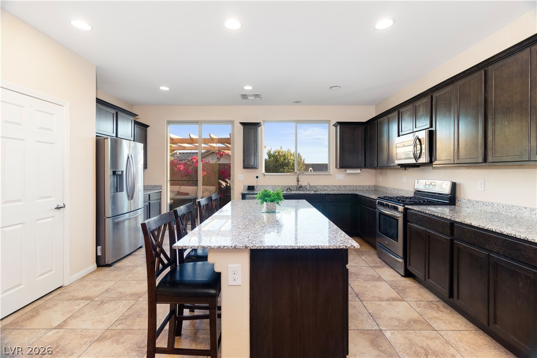 2079 Port Royal Drive Laughlin, NV 89029 - Photo 13 of 86 Kitchen with a kitchen bar, stainless steel appliances, a kitchen island, light stone countertops, and recessed lighting