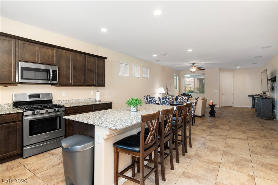 2079 Port Royal Drive Laughlin, NV 89029 - Photo 19 of 86 Kitchen featuring stainless steel appliances, a kitchen breakfast bar, dark brown cabinets, a kitchen island, and recessed lighting