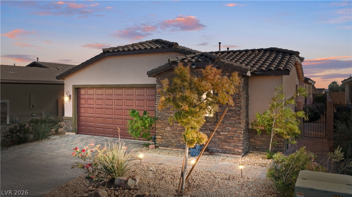 2079 Port Royal Drive Laughlin, NV 89029 - Photo 2 of 86 Mediterranean / spanish-style house with stucco siding, a tiled roof, stone siding, an attached garage, and decorative driveway