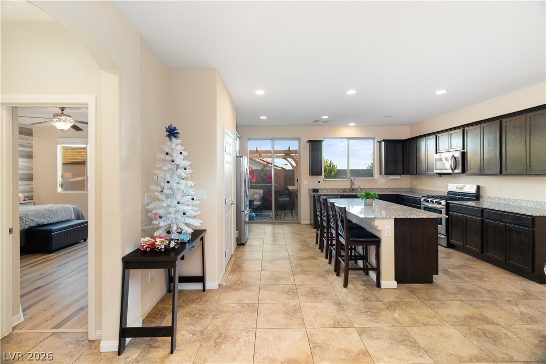 2079 Port Royal Drive Laughlin, NV 89029 - Photo 22 of 86 Kitchen featuring appliances with stainless steel finishes, a kitchen bar, a center island, light stone countertops, and entry to the Primary Bedroom