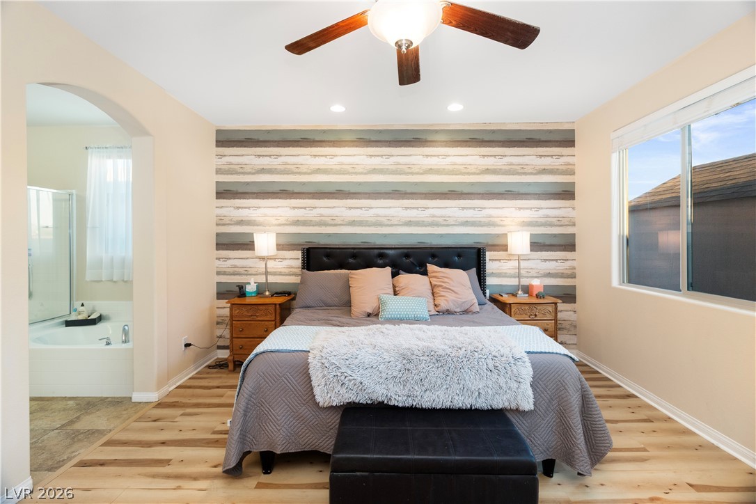 2079 Port Royal Drive Laughlin, NV 89029 - Photo 24 of 86 Primary Bedroom with an accent wall, multiple windows, wooden walls, wood finished floors, and connected bathroom