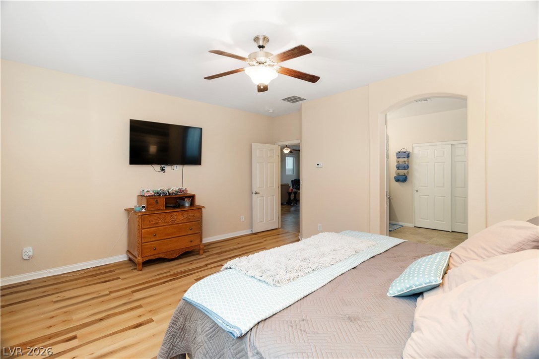 2079 Port Royal Drive Laughlin, NV 89029 - Photo 26 of 86 Primary Bedroom with arched walkways, a ceiling fan, and light wood-style flooring
