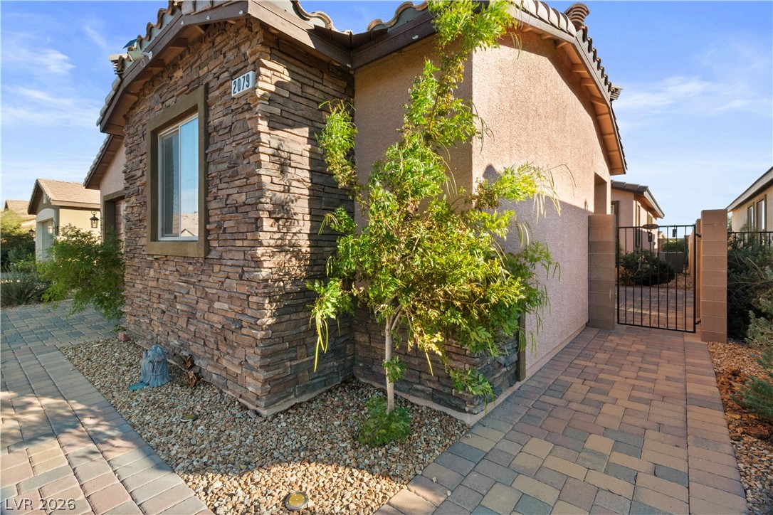 2079 Port Royal Drive Laughlin, NV 89029 - Photo 4 of 86 View of property exterior with stone siding, a gate, and stucco siding