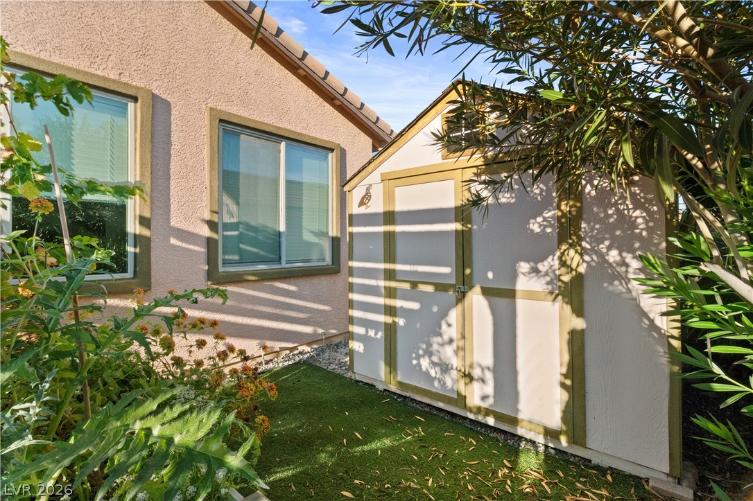 2079 Port Royal Drive Laughlin, NV 89029 - Photo 58 of 86 View of side of home with a tile roof, stucco siding, a storage shed, and a lawn