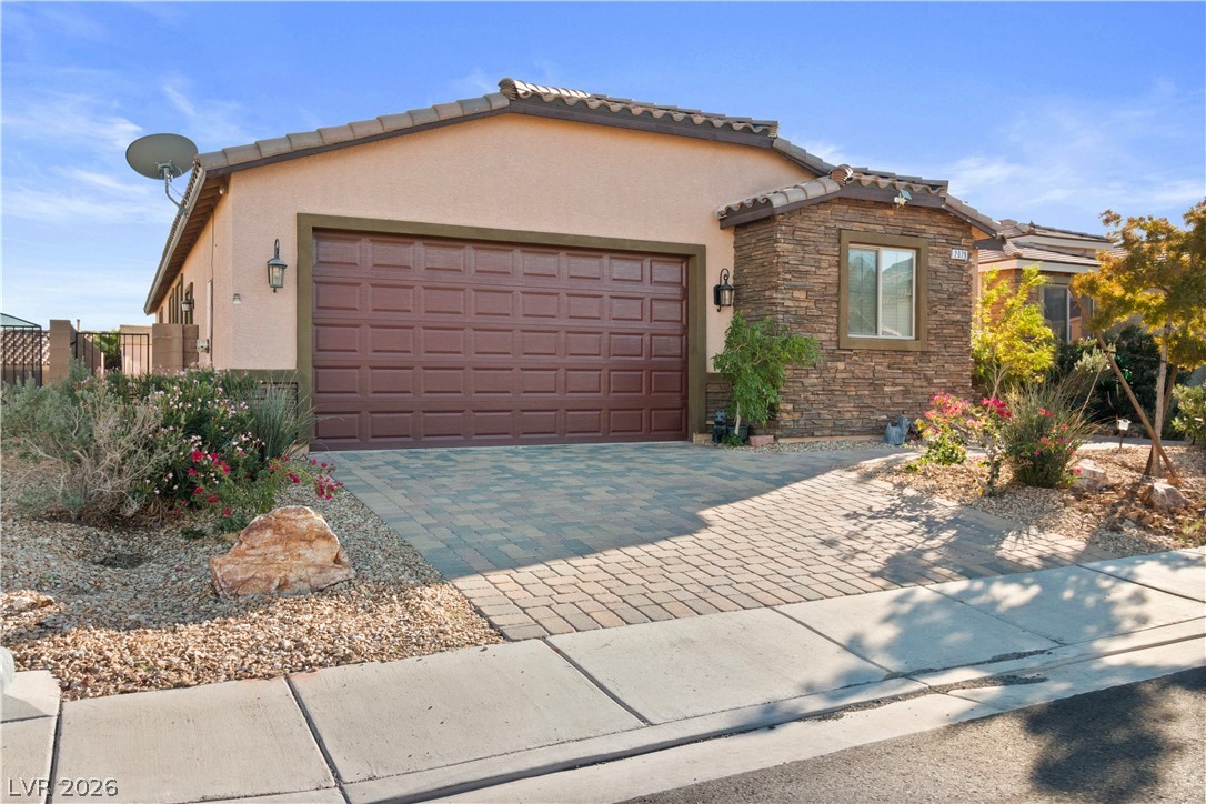 2079 Port Royal Drive Laughlin, NV 89029 - Photo 64 of 86 View of front of property with stone siding, stucco siding, decorative driveway, and an attached garage