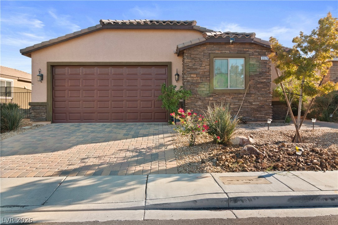 2079 Port Royal Drive Laughlin, NV 89029 - Photo 65 of 86 View of front of home with stone siding, stucco siding, decorative driveway, and a garage
