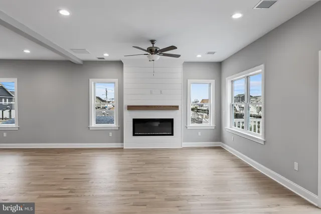 an empty room with windows and a fireplace
