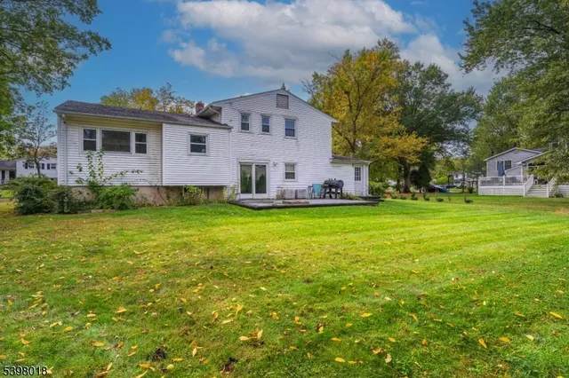 a view of a house with a big yard and large trees