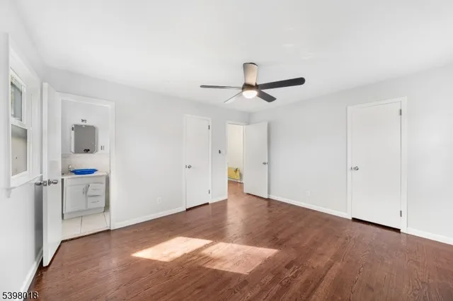 a view of a livingroom with wooden floor and a ceiling fan