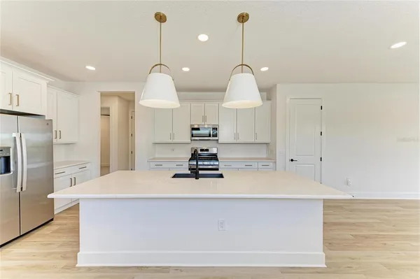 a kitchen with stainless steel appliances granite countertop white cabinets and a stove top oven