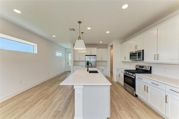 a kitchen with a sink and a wooden floor