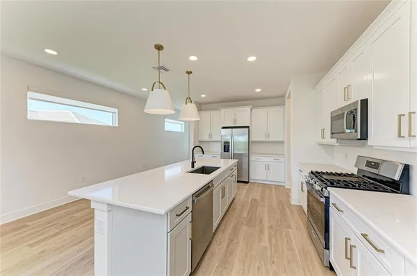 a kitchen with stainless steel appliances a sink stove and cabinets