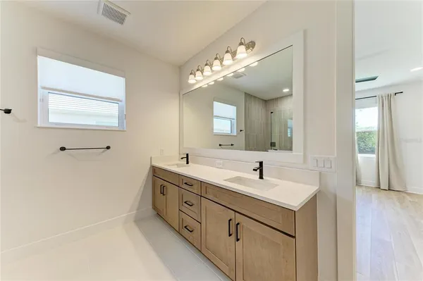 a bathroom with a double vanity sink and a mirror