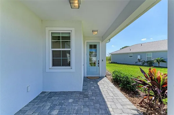 a large kitchen with stainless steel appliances a large counter top a stove a sink and a chandelier