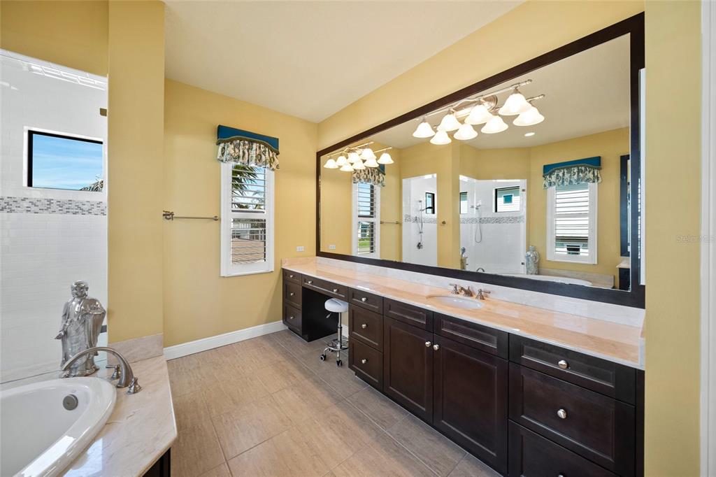 471 Bayshore Road Nokomis, FL 34275 - Photo 21 of 95 a spacious bathroom with a double vanity sink a large mirror and a bathtub