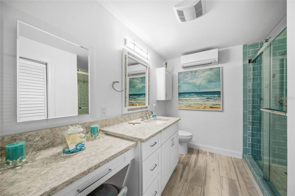 471 Bayshore Road Nokomis, FL 34275 - Photo 27 of 95 a bathroom with a granite countertop sink a toilet a mirror and window