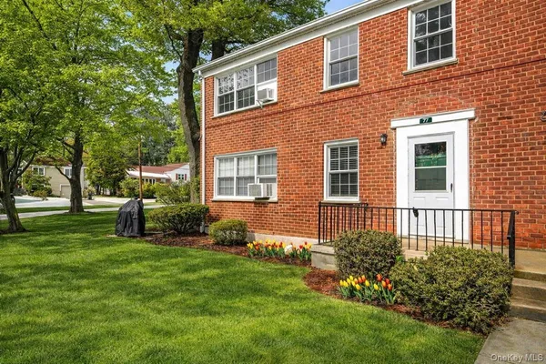 a view of a house with a yard and sitting area